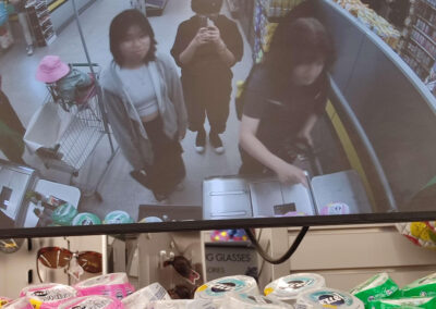 a picture of a group of three friends in a dollorama self-checkout camera reflection